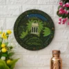 Decor Home Craft Handmade Pichwai Painting with a traditional design hanging on a white brick wall in an office, featuring a gazebo scene surrounded by lush greenery under a night sky, flanked by pink and yellow flowers and a copper vessel.